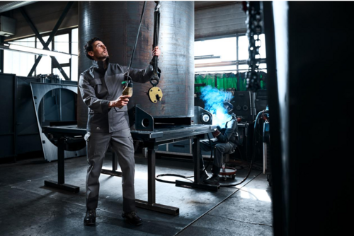 Mann in Werkstatt mit Arbeitskleidung