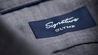 Neues Logo OLYMP Signature auf einem Hemdskragen