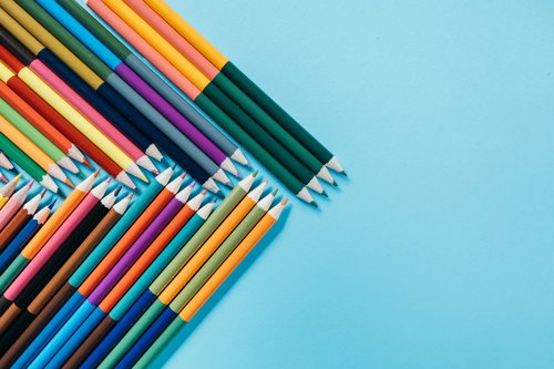 Bleistifte in bunt bilden ein pfeil auf blauen Hintergrund