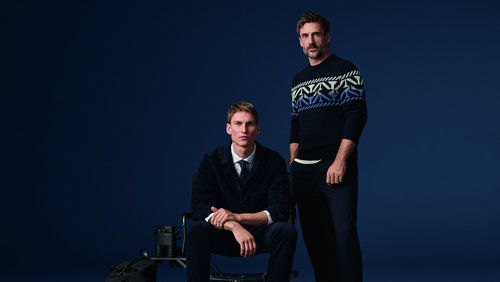 Zwei Männer in Olymp-Kleidung, einer sitzt, der andere steht