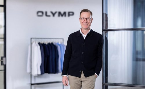 Peter Hoever vor einer weißen Wand mit OYMP-Aufschrift