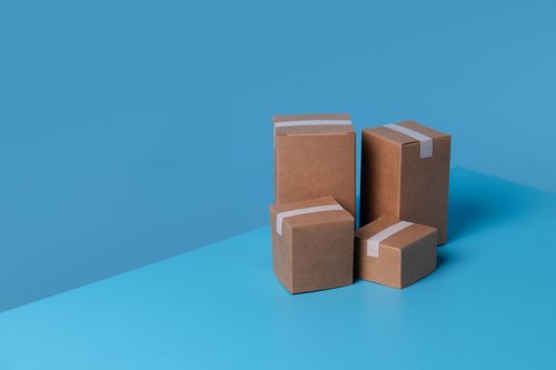 Gestapelte Pappkartons vor blauem Hintergrund