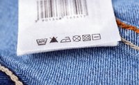 Nahaufnahme eines Stoff-Pflegeetiketts, das auf blauen Jeans genäht ist.