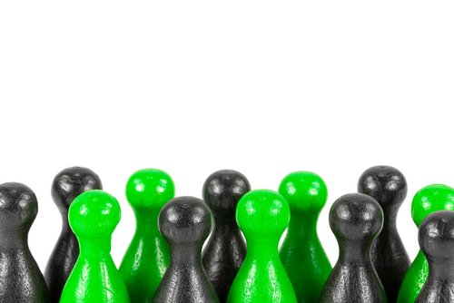 Grüne und schwarze Männchen stehen nebeneinander vor einem weißen Hintergrund.