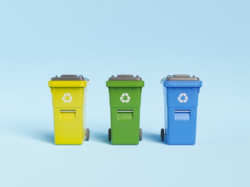 3D-Darstellung von bunten Recyclingbehältern für verschiedene Müllarten in Reihe vor blauem Hintergrund