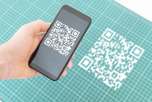 Hand hält ein Smartphone und scannt den qr-Code