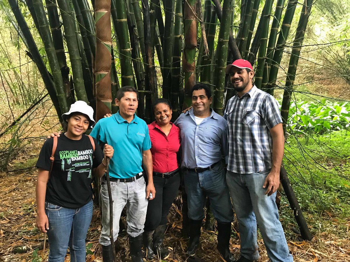 Vor einigen Bambusstämmen in Nicaragua stehen fünf Personen gemeinsam Arm in Arm.