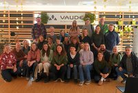 Jubilare vor einer Wand mit Aufschrift VAUDE