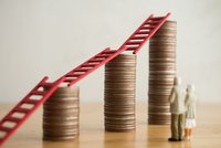 Zwei schemenhafte ältere Menschen blicken auf Stapel mit Münzen, auf denen rote Leitern liegen.