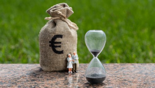 Zwei Rentnern neben einen Sack mit Euro Zeichen drauf und eine Zeituhr