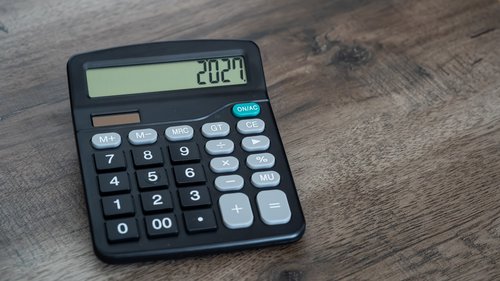 Taschenrechner auf Tisch mit 2027 auf dem Bildschirm