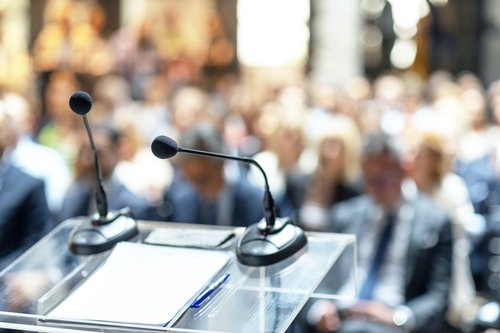 Mikrofon auf Pult vor Menge bei Konferenz