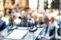 Mikrofon auf Pult vor Menge bei Konferenz