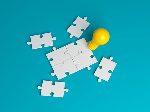 Puzzleteile und eine Glühbirne