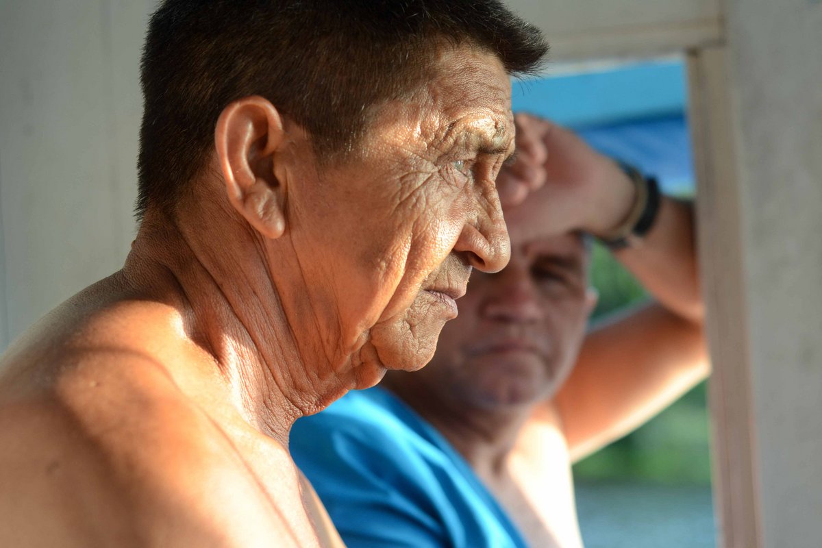 Zwei Männer stehen gemeinsam im Führerhäuschen eines Boots. Der eine blickt nachdenklich nach vorne.