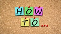 Zettel mit Beschriftung How To hängen an Korkplatte