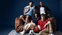 Drei Männer und eine Frau mit Polohemden, die für die Fußball WM kreiert wurden.
