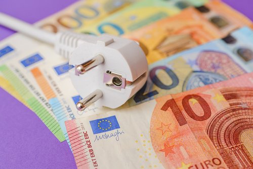 Elektrischer Stecker, Euro-Papiergeld-Banknoten. Lila Innenhintergrund. 