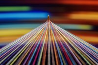 Konvergierender mehrfarbiger Nähfaden mit Bewegungsunschärfe-Effekt, bunter Hintergrund