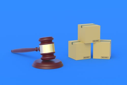 Pappkartons vor blauem Hintergrund mit Rechtshammer, der für Gesetzgebung steht