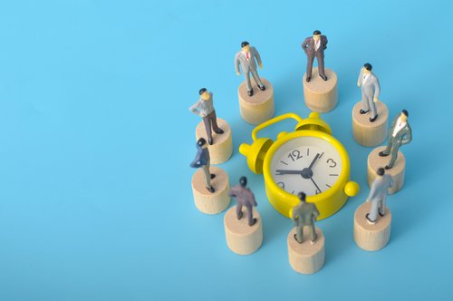 Wecker im Kreis von Personen umrundet