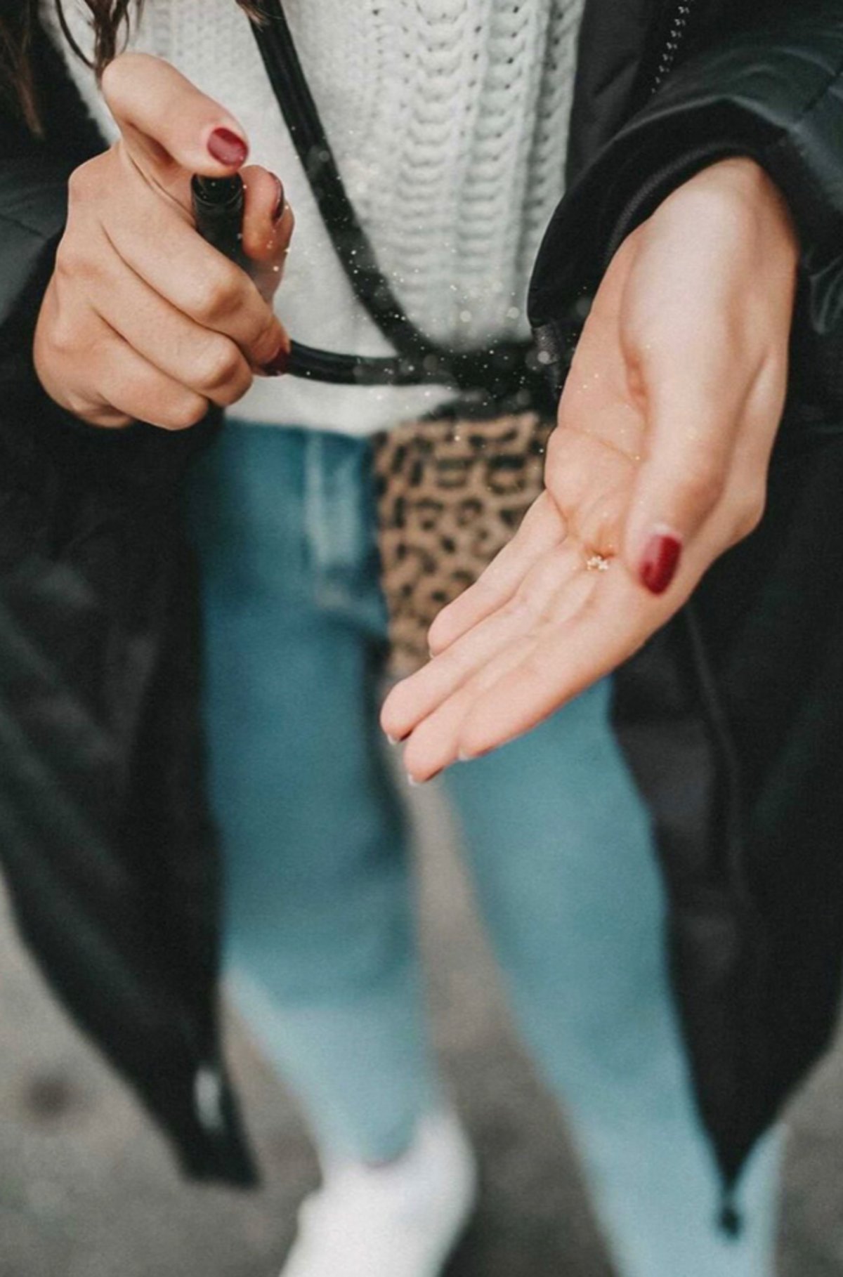Aus einer Handykette von PortHy wird Desinfektionsspray auf eine Hand gesprüht.