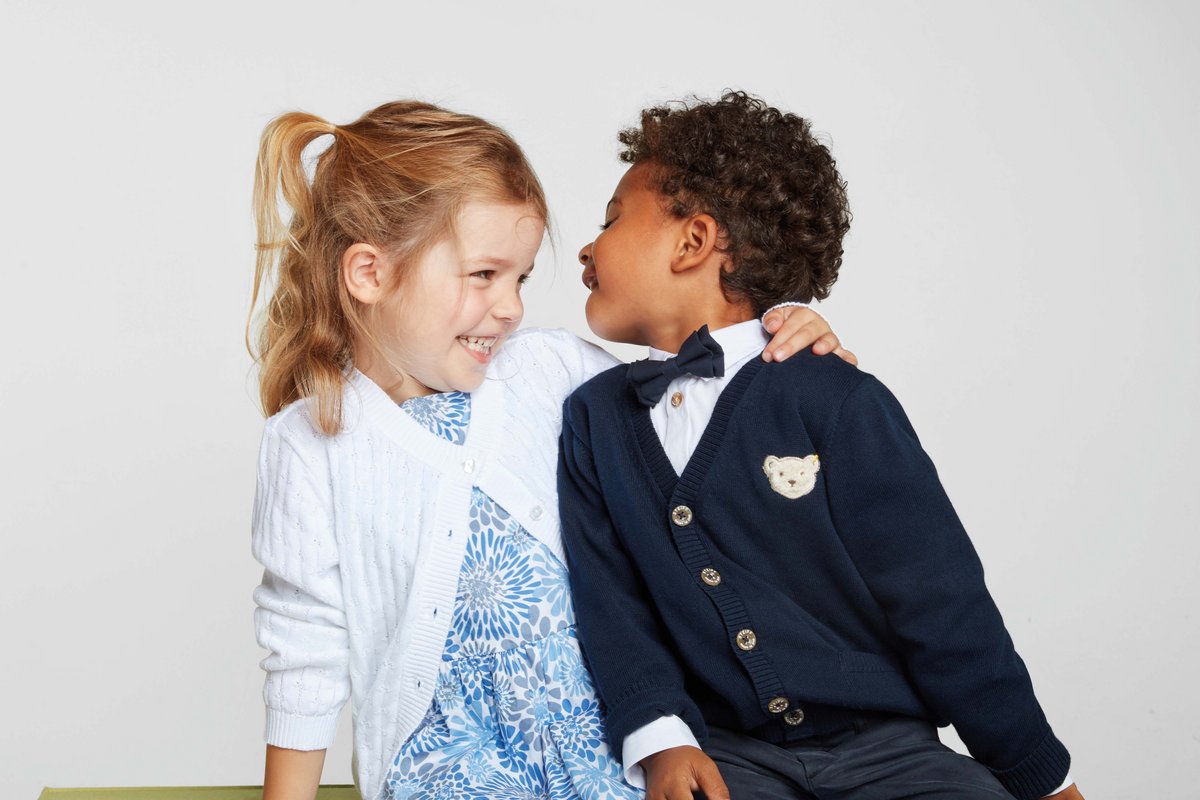 Ein kleiner Junge in der GOTS-zertifizierten Kinderbekleidung von Steiff ärgert ein Mädchen.