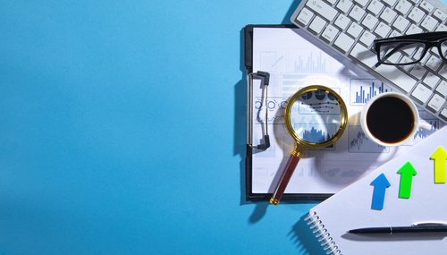 Computertastatur, Brille, Maus, Notizblock, Stift, Kaffee.