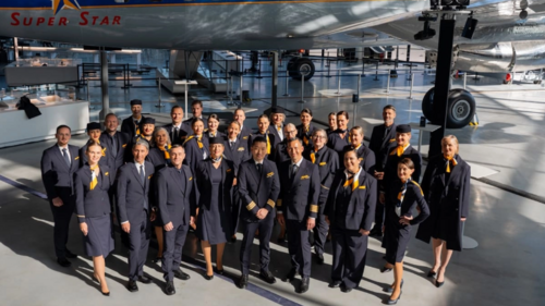Crew mit neuen Uniformen vor einem Lufthansa-Flugzeug