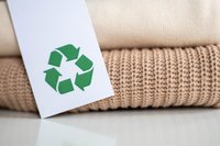 Zwei Pullover mit einem Recycling Zeichen davor als Etikett