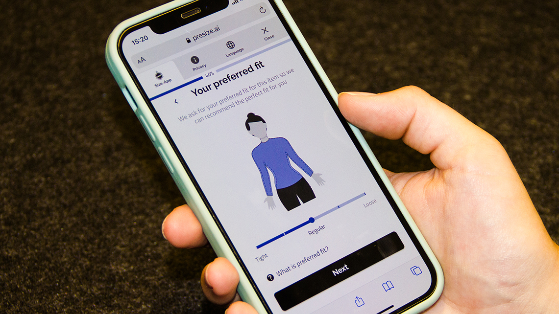 Hand hält ein Handy. Auf dem Display ist die App des Unternehmens Presize zu sehen.