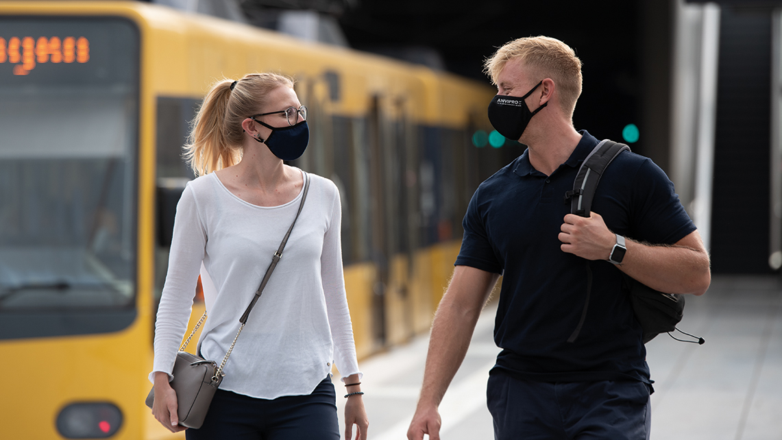 Ein Mann und eine Frau mit Masken an einer U-Bahnhaltestelle