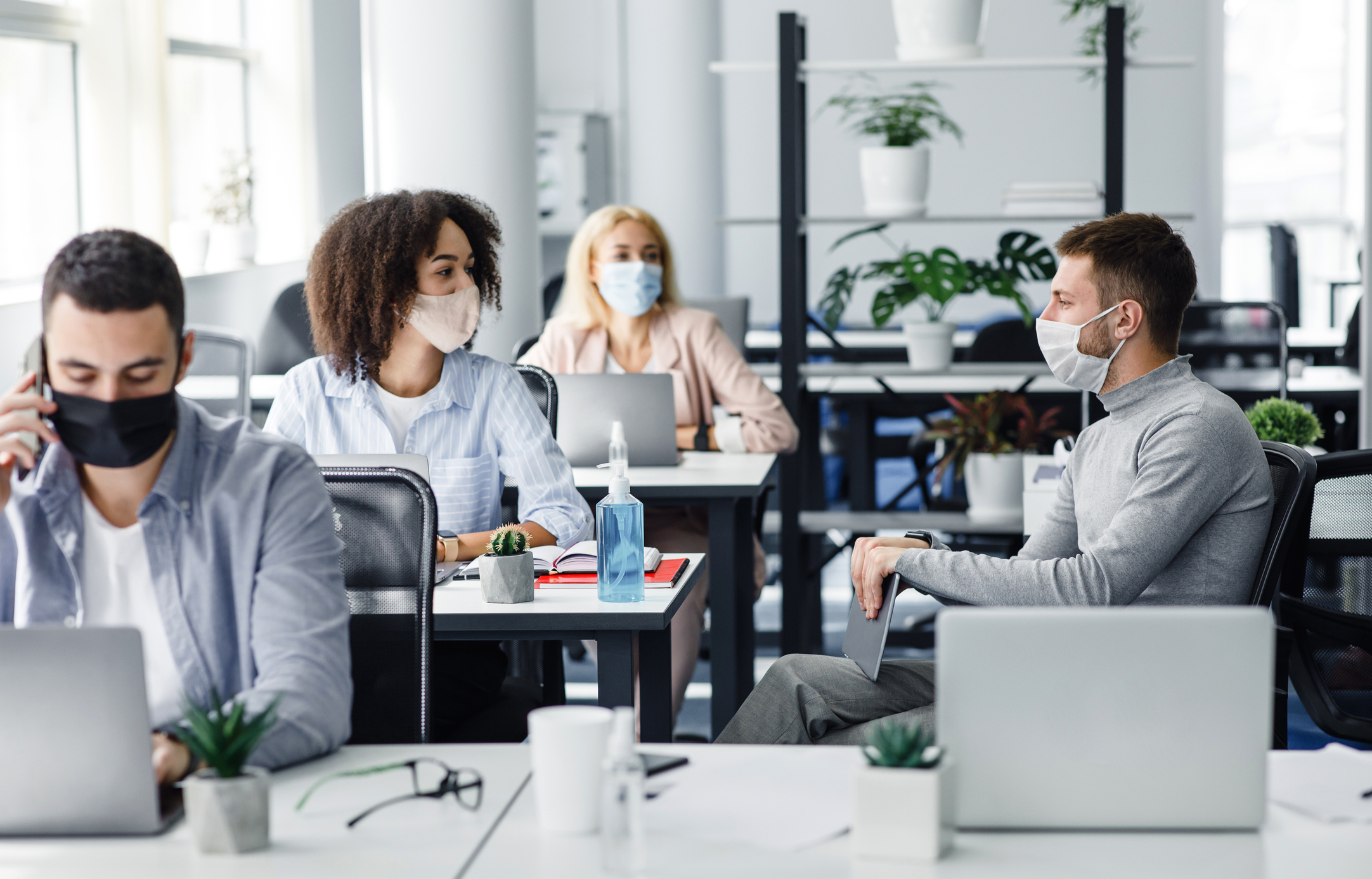 Vier Personen im Büro mit Mundschutz