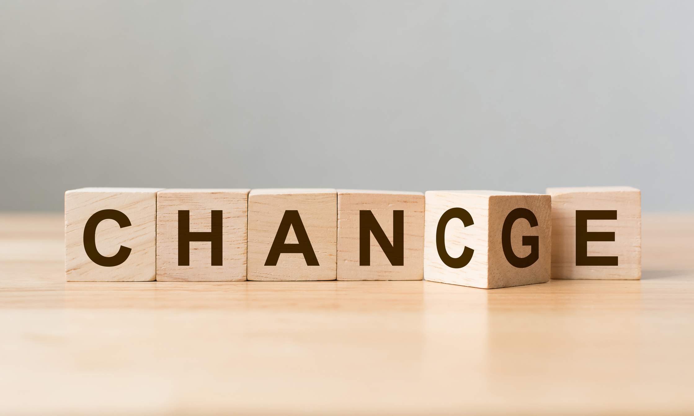 Holzwürfel flip mit Wort "change" zu "Chance" auf Holztisch.