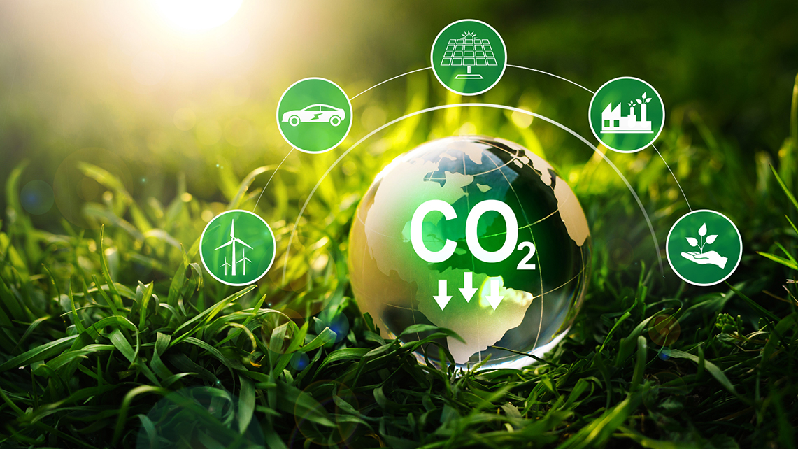 Glaskugel mit Beschriftung CO2 liegt auf Grad umgegeben von Symbolen für Energieeinsparungen