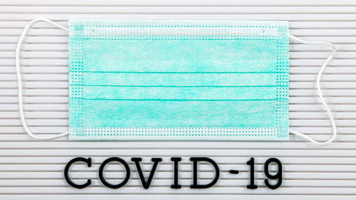 Medizinische Maske unter der Covid-19 steht