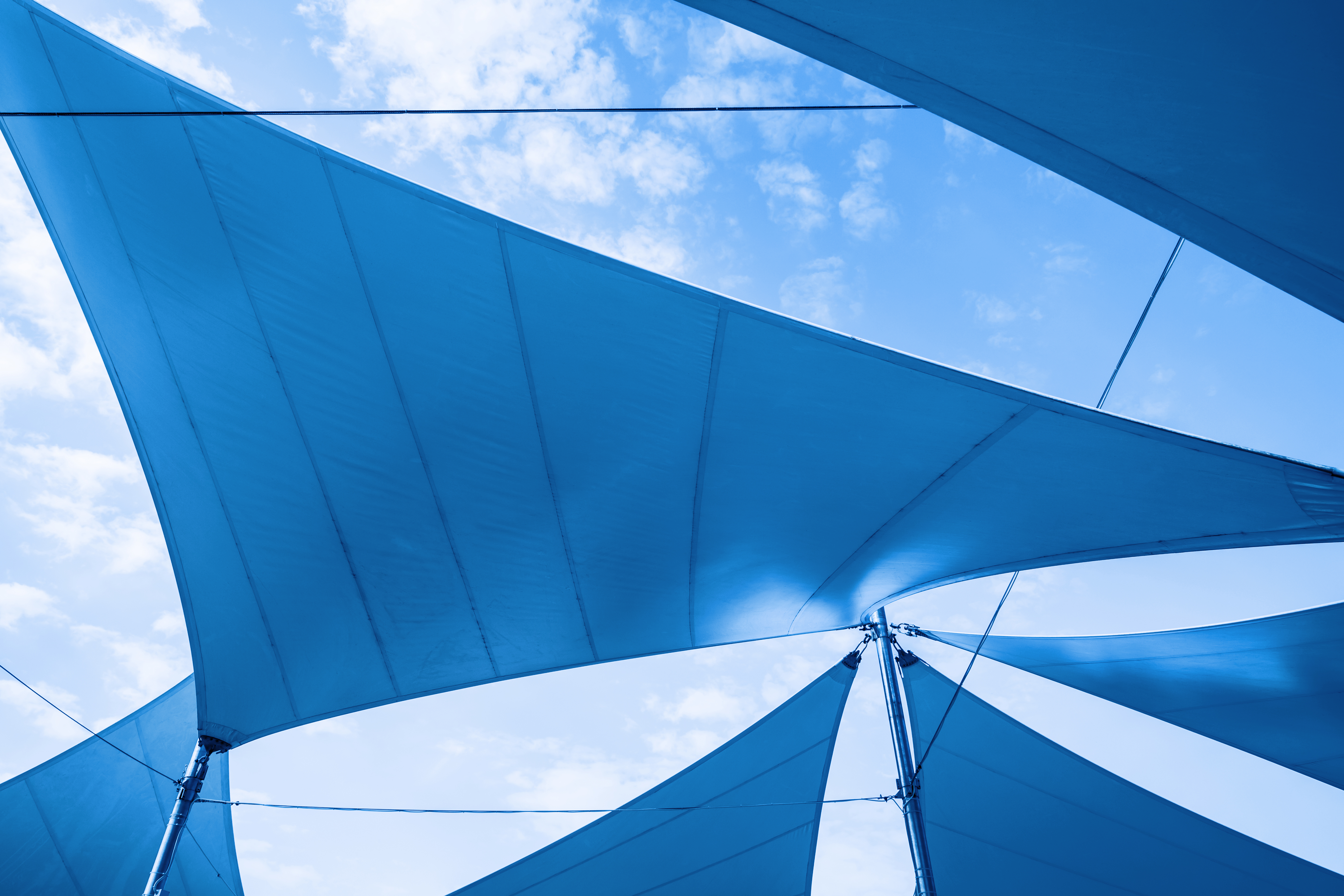 Sonnensegel schützen im Sommer bei strahlend blauem Himmel vor der Sonne.