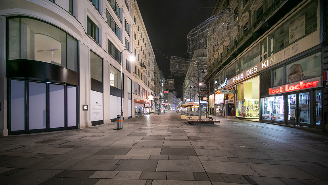 Menschenleere Einkaufsstraße bei Nacht.