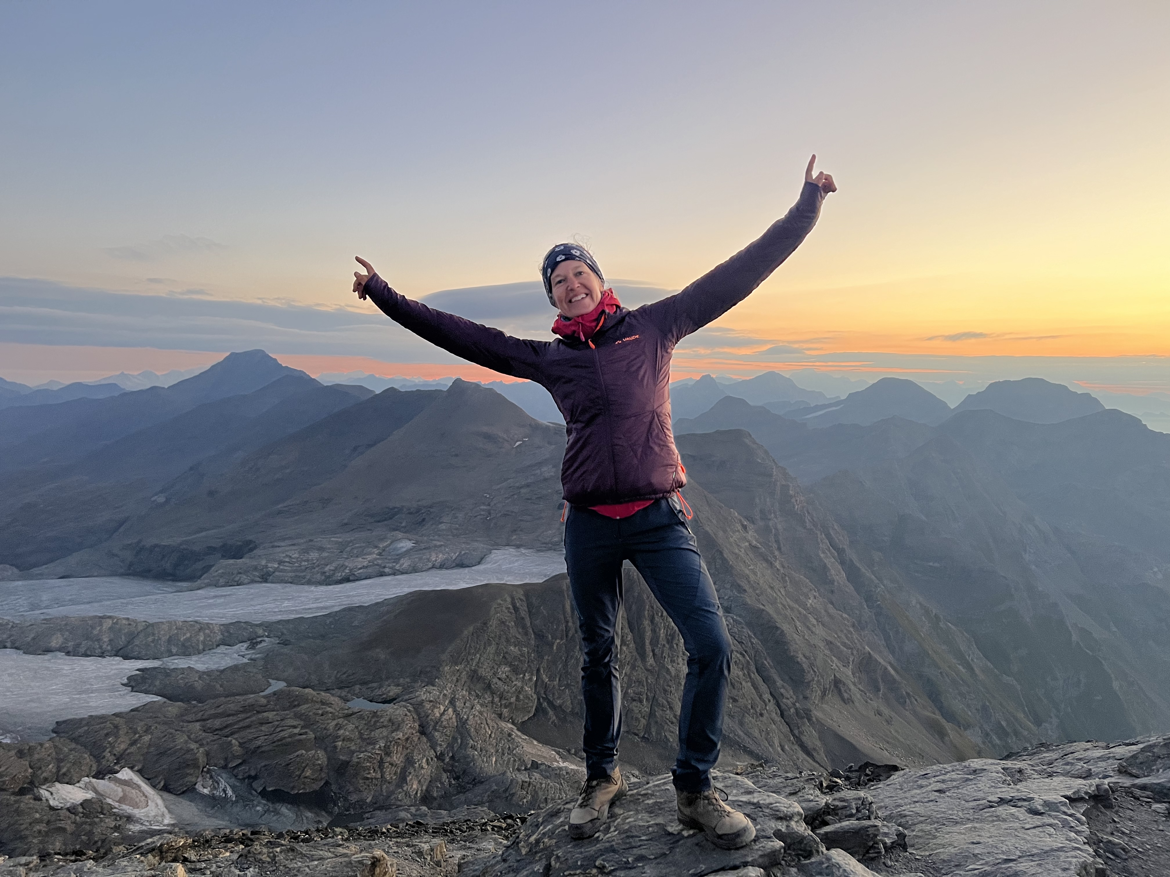 Antje von Dewitz hebt die Arme in den Himmel in den Alpen.