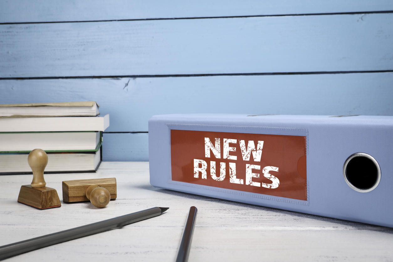 Dokumentenmappe mit der Aufschrift "New Rules" liegt auf einem Schreibtisch.