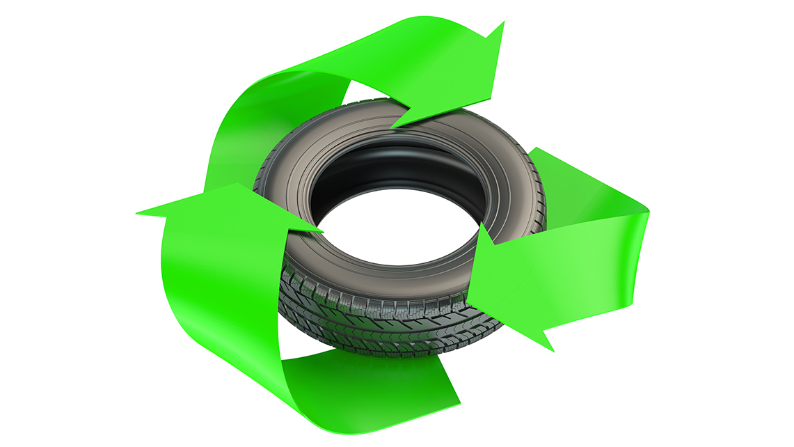 Alter Autoreifen innerhalb eines grünen Recyclingsymbols