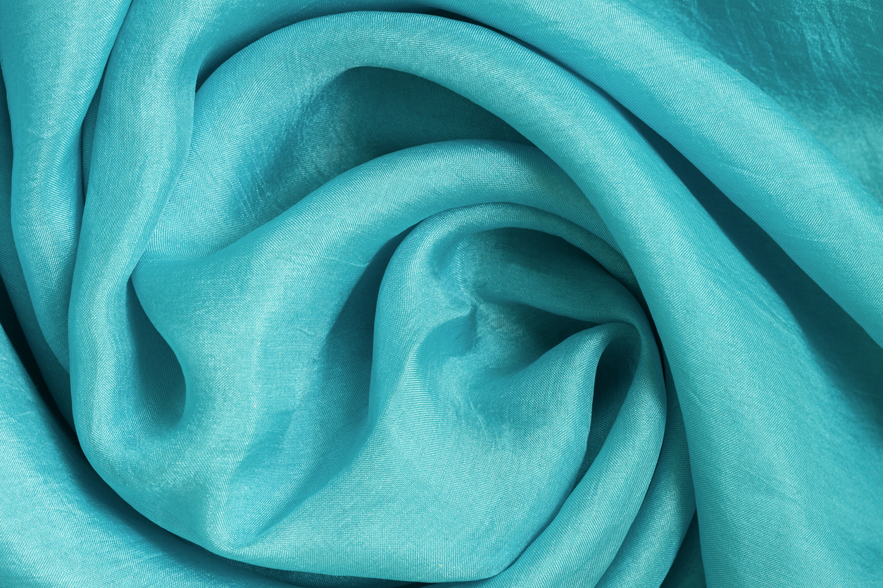 Stoff in spiralförmigen Wellen und Falten verdreht, modische Trendfarbe Turmalin