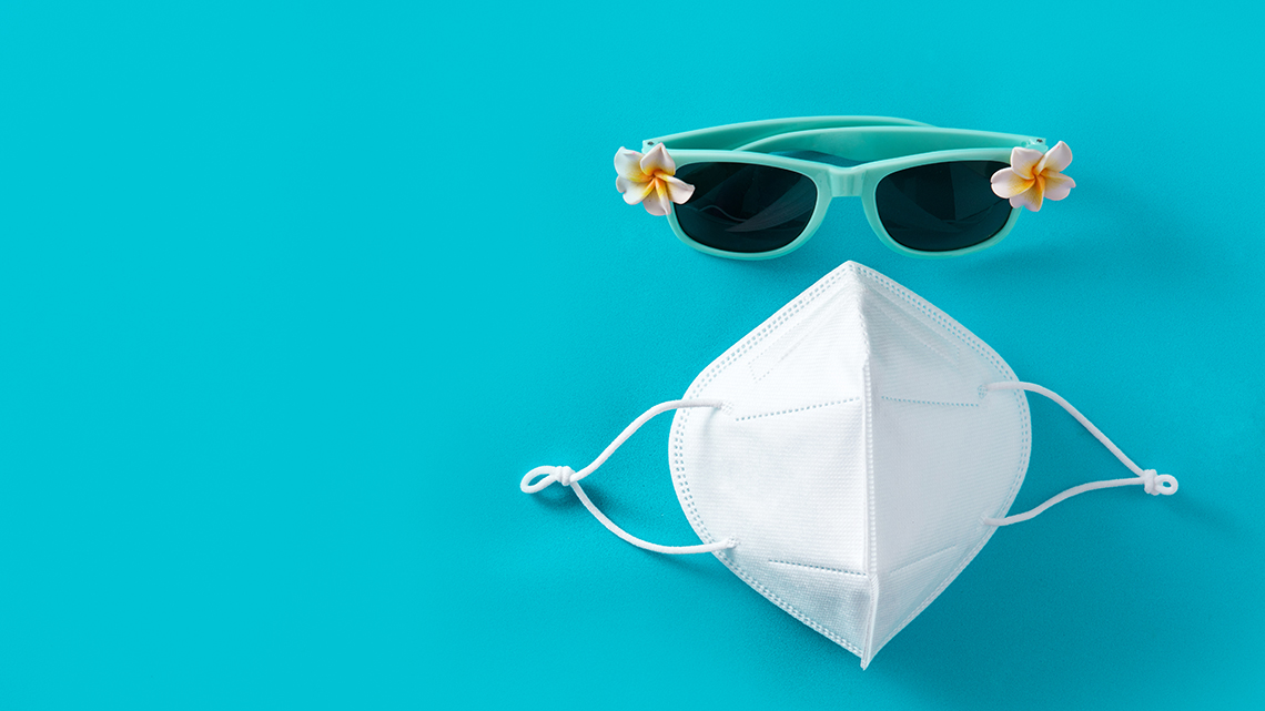 Auf einem türkisfarbenen Hintergrund liegt eine sommerliche Sonnenbrille in der selben Farbe und darunter eine FFP2-Maske.