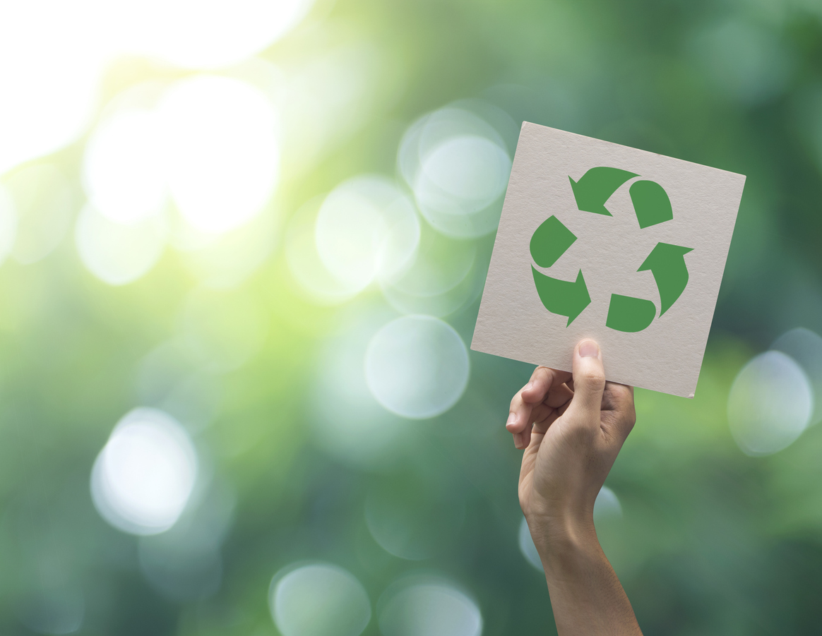 Hand, die Recycling-Symbol auf grün Bokeh Hintergrund. Eco und das Erde-Konzept zu retten.