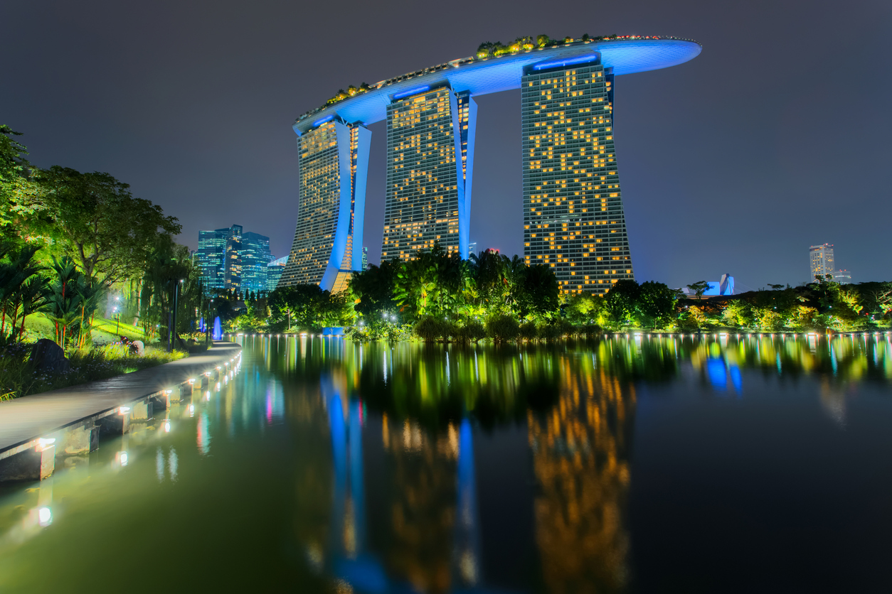 Berühmte Wahrzeichen der Marina Bay Sands Hotel spiegelt sich im Wasser. Nachts beleuchtet.