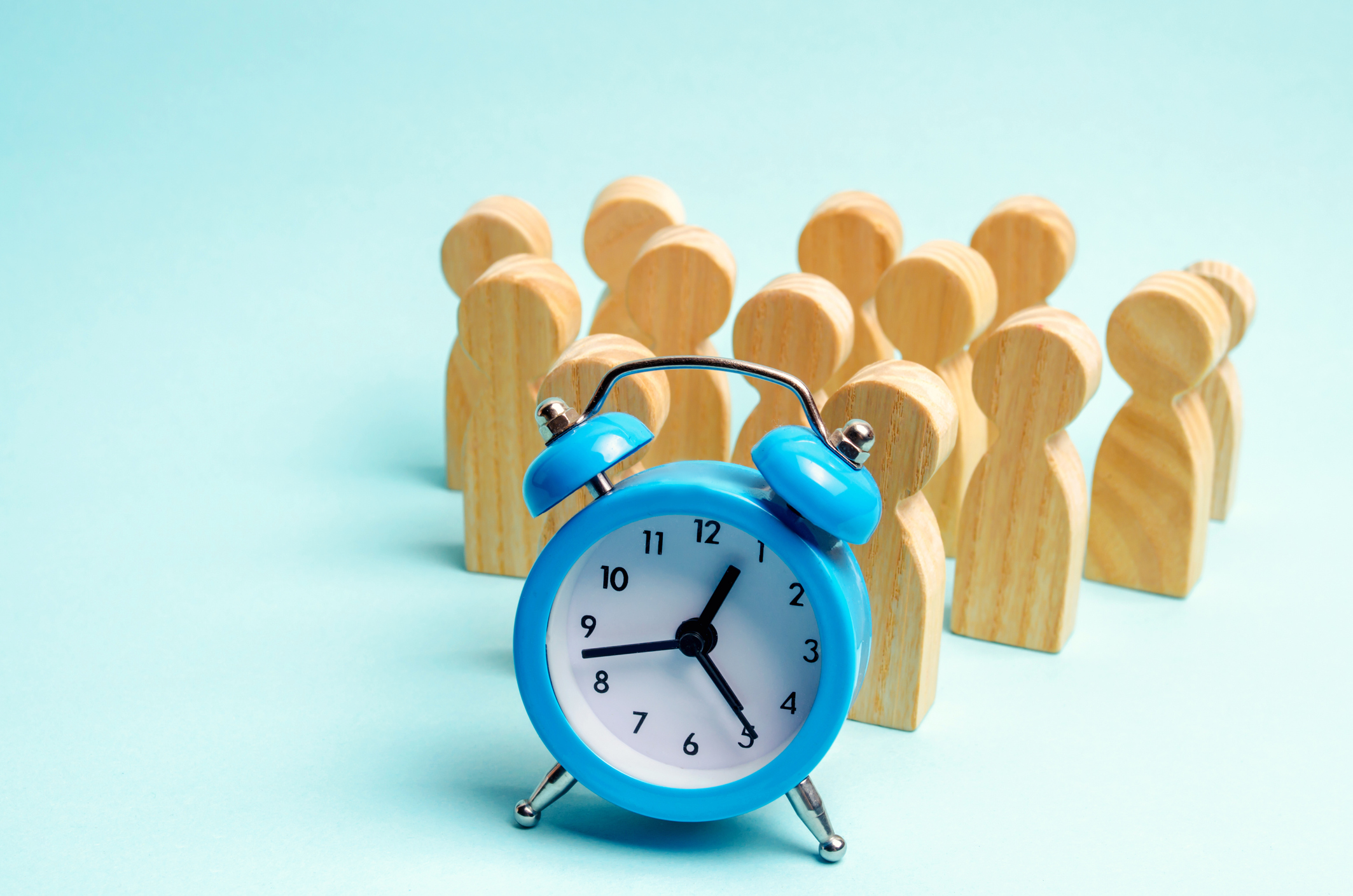 Weckeruhr mit Holzfiguren dahinter