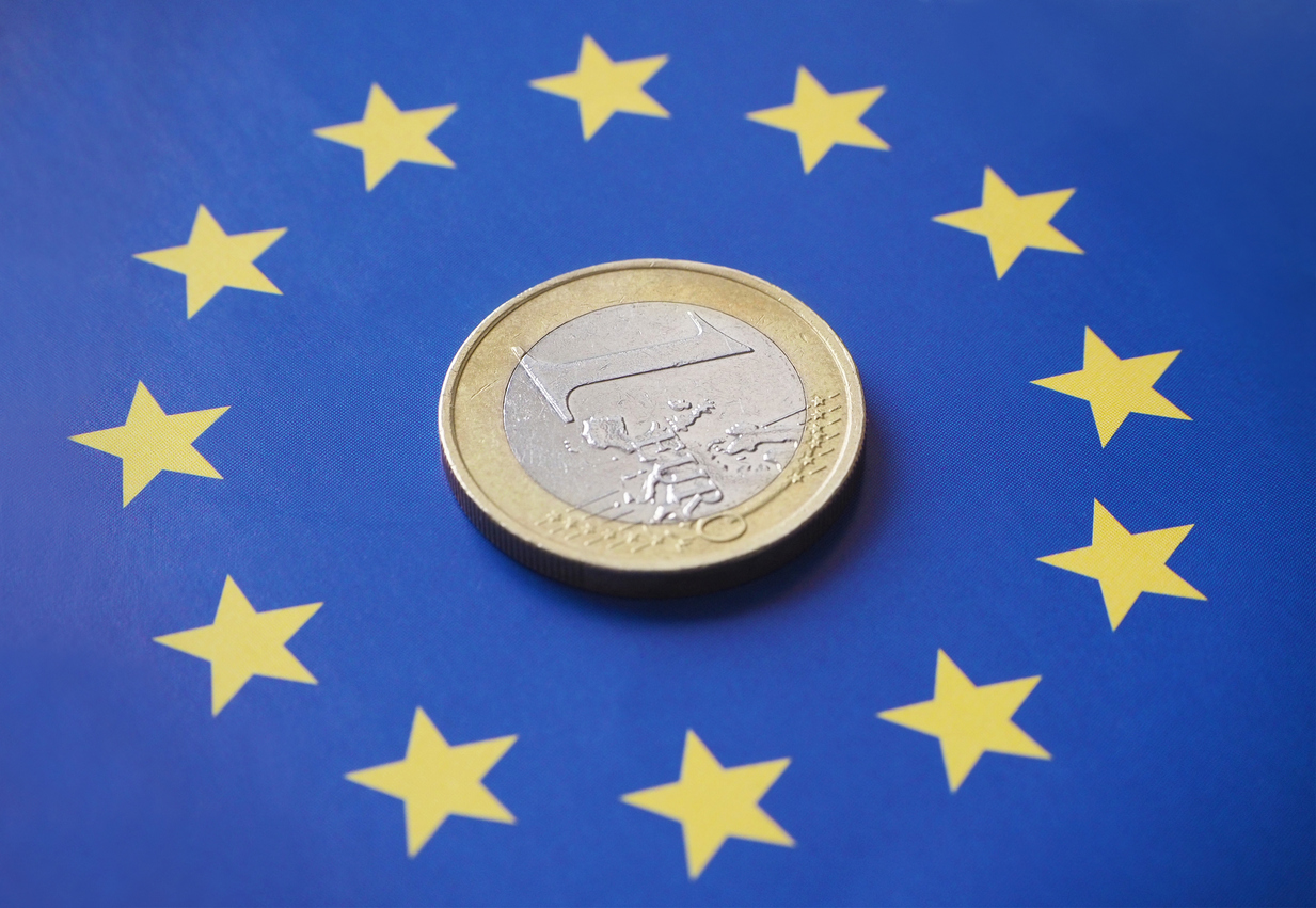 Nahaufnahme von einer 1-Euro-Münze auf der europäischen Flagge