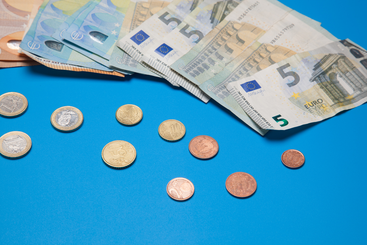 Eurobanknoten und Münzen auf blauem Untergrund