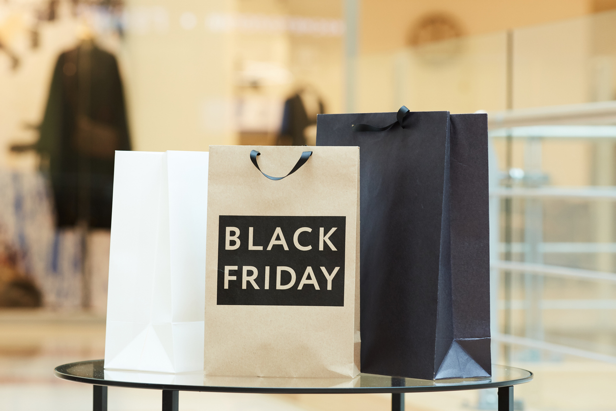 schwarz-weiße Einkaufstaschen, die am Black Friday im Einkaufszentrum auf dem Tisch stehen