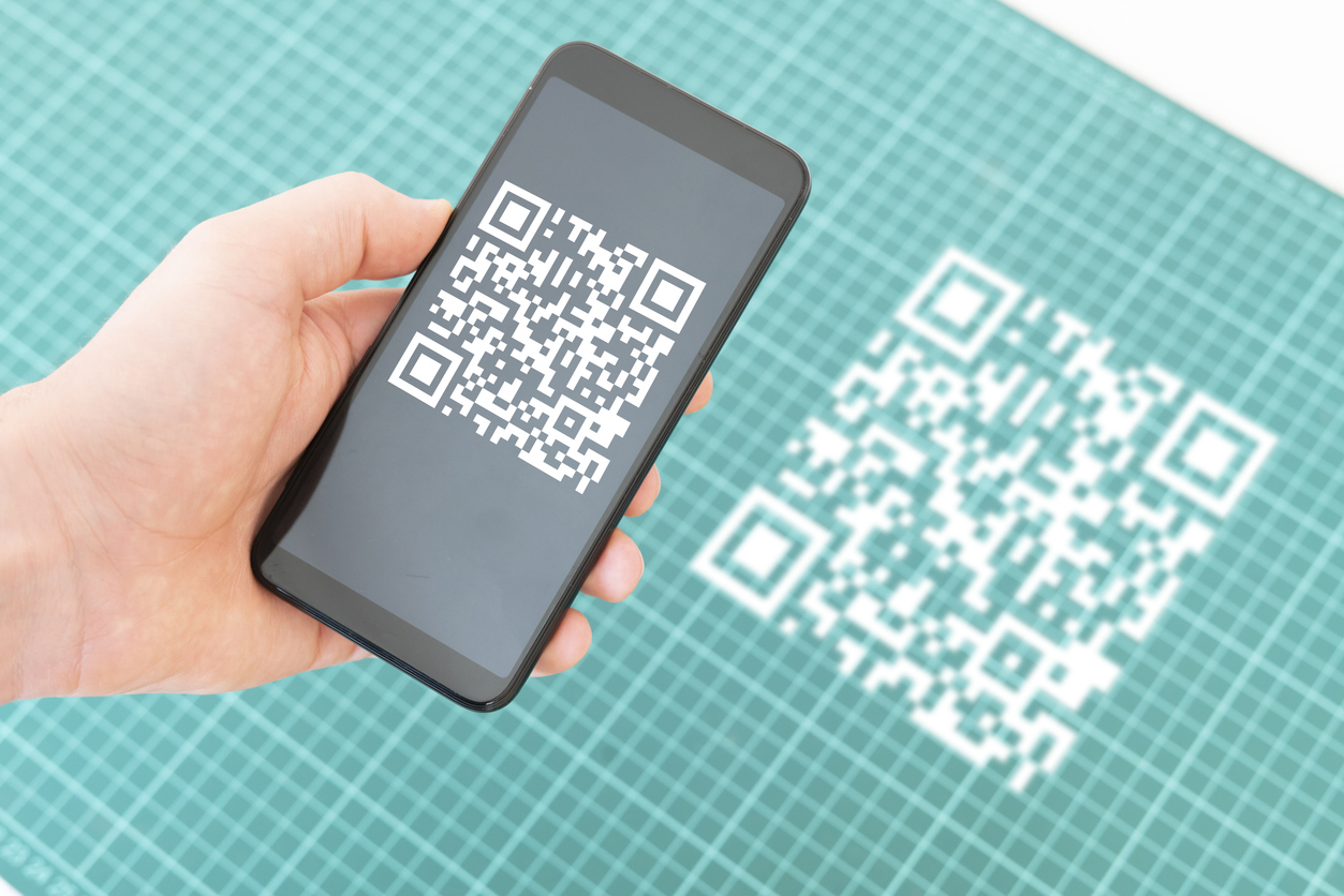 Hand hält ein Smartphone und scannt den qr-Code